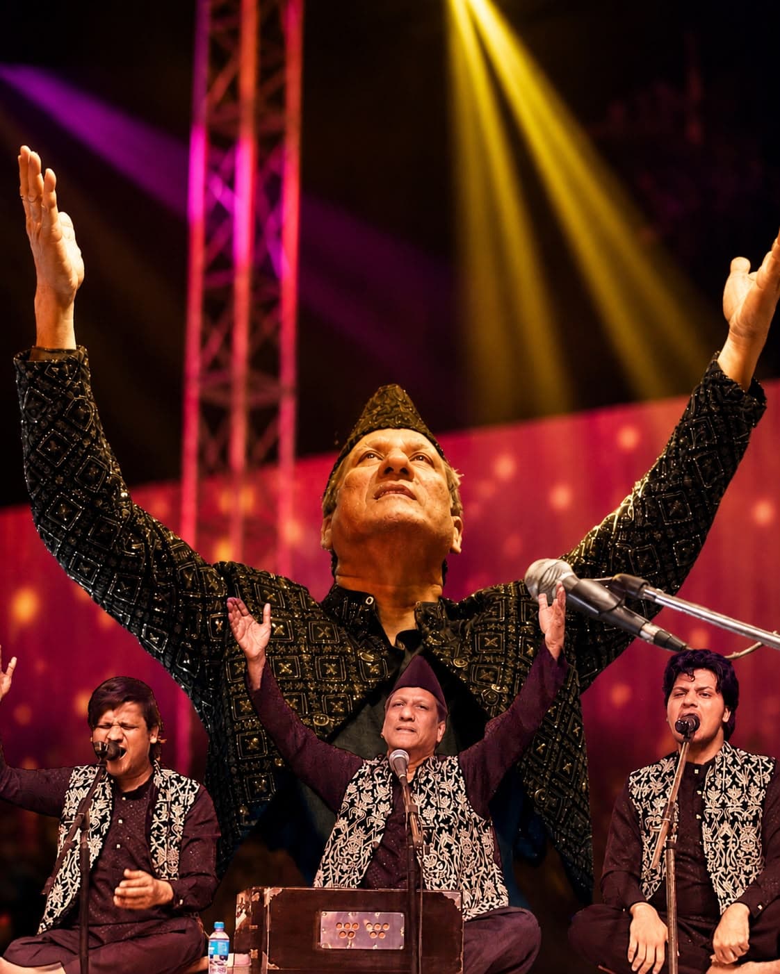 Ustad Chand Nizami and Nizami Bandhu performing qawwali beneath colorful stage lights