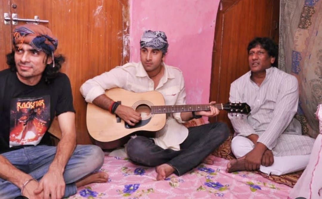 Ranbir Kapoor holding a guitar alongside Imtiaz Ali at a musical gathering